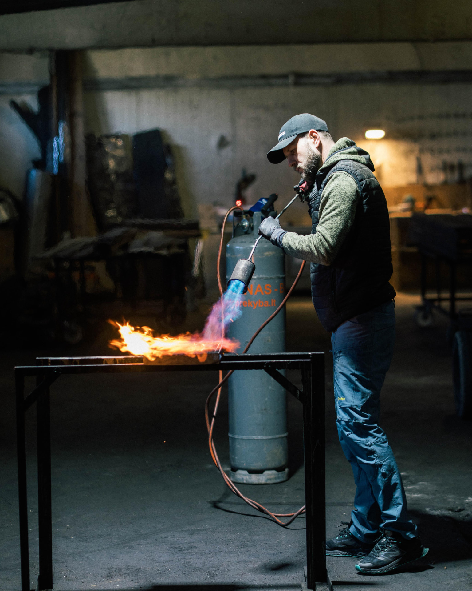 Inflamed craftsman charring timber with an open flame in the factory