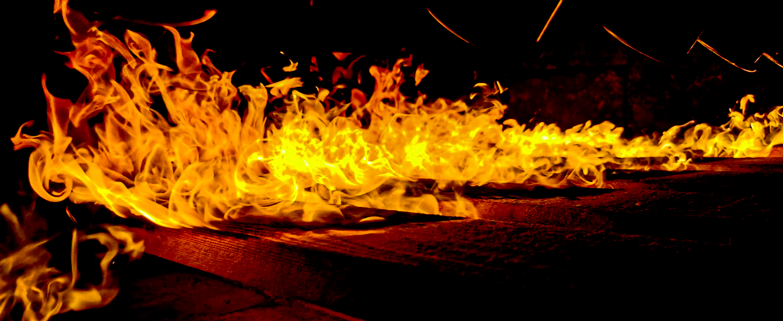 Timber boards burning under open flame during the Japanese charring process